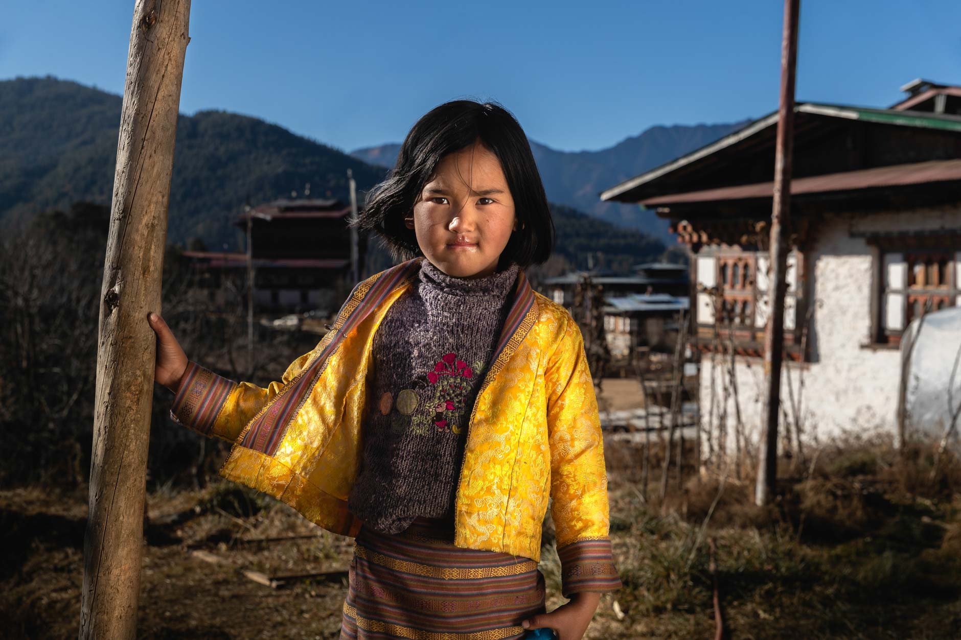 Portrait photography of a young girl wearing a yellow jacket in Bhutan