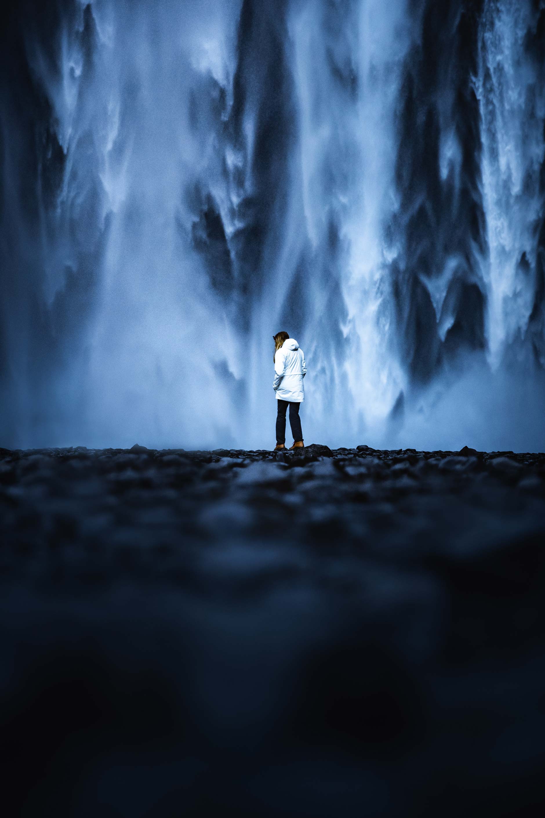 Hanna Roshak wearing a white jacket at Skogafoss waterfall in Iceland