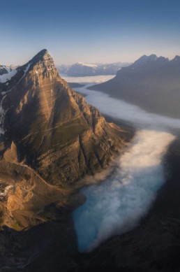 Aerial photography of mount chephren in Banff National Park during sunrise above the fog Photo by Andrew Studer