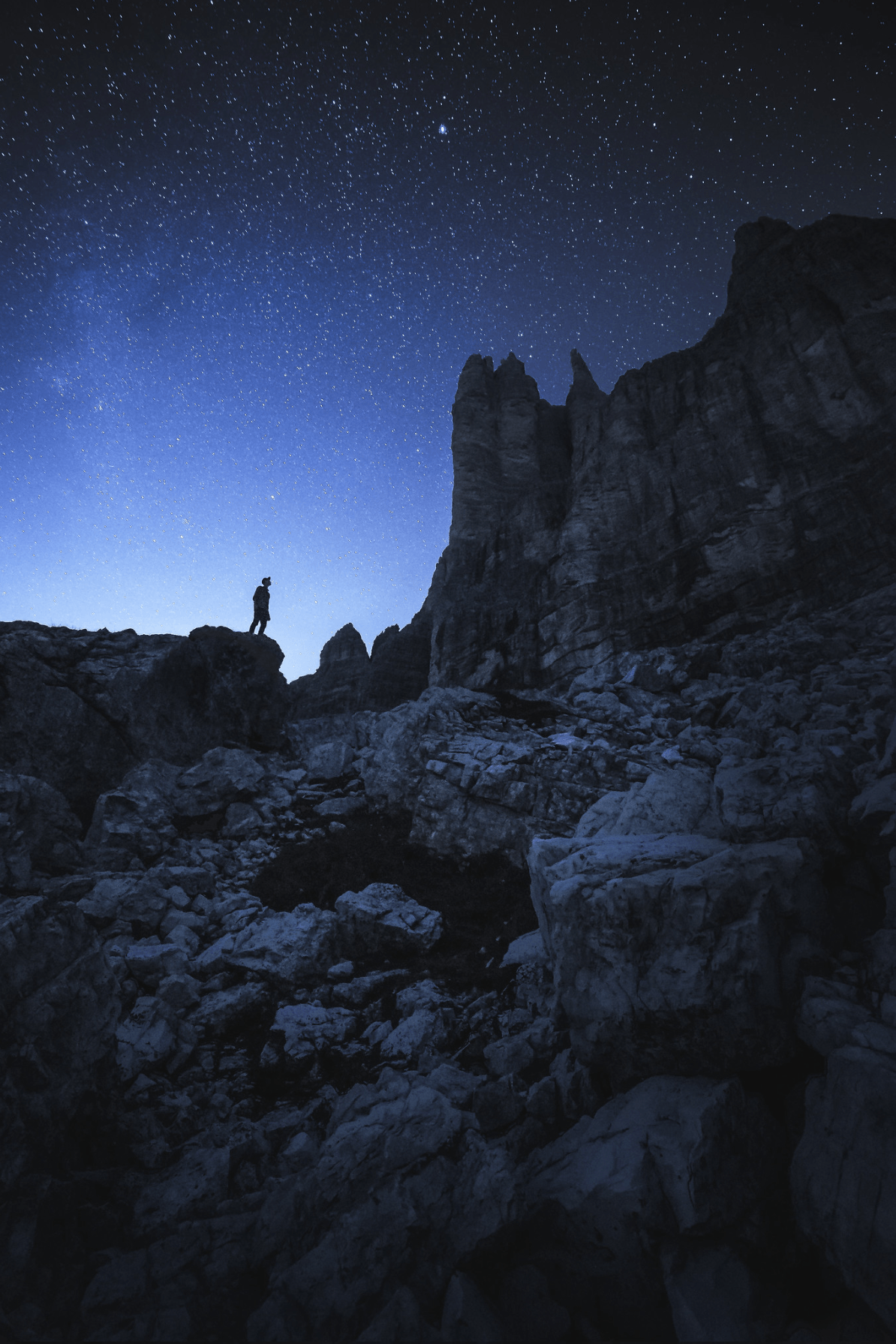 Photography of a person under the stars over Tre Cime in the Italian Dolomites