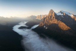 Aerial photography from a helicopter of mount chephren in Banff National Park during sunrise above the fog Photo by Andrew Studer