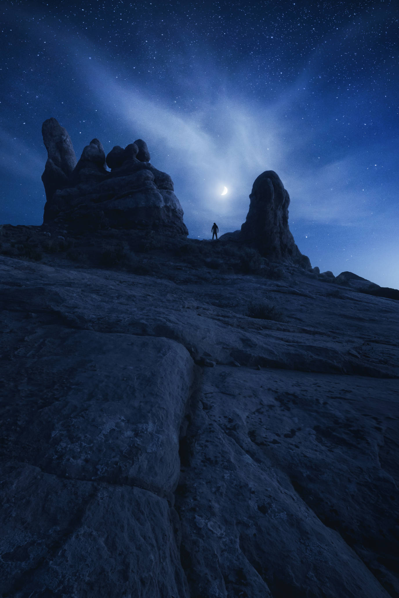 Night photography of the stars and a person at Windows Arch in Arches National Park, Moab, Utah