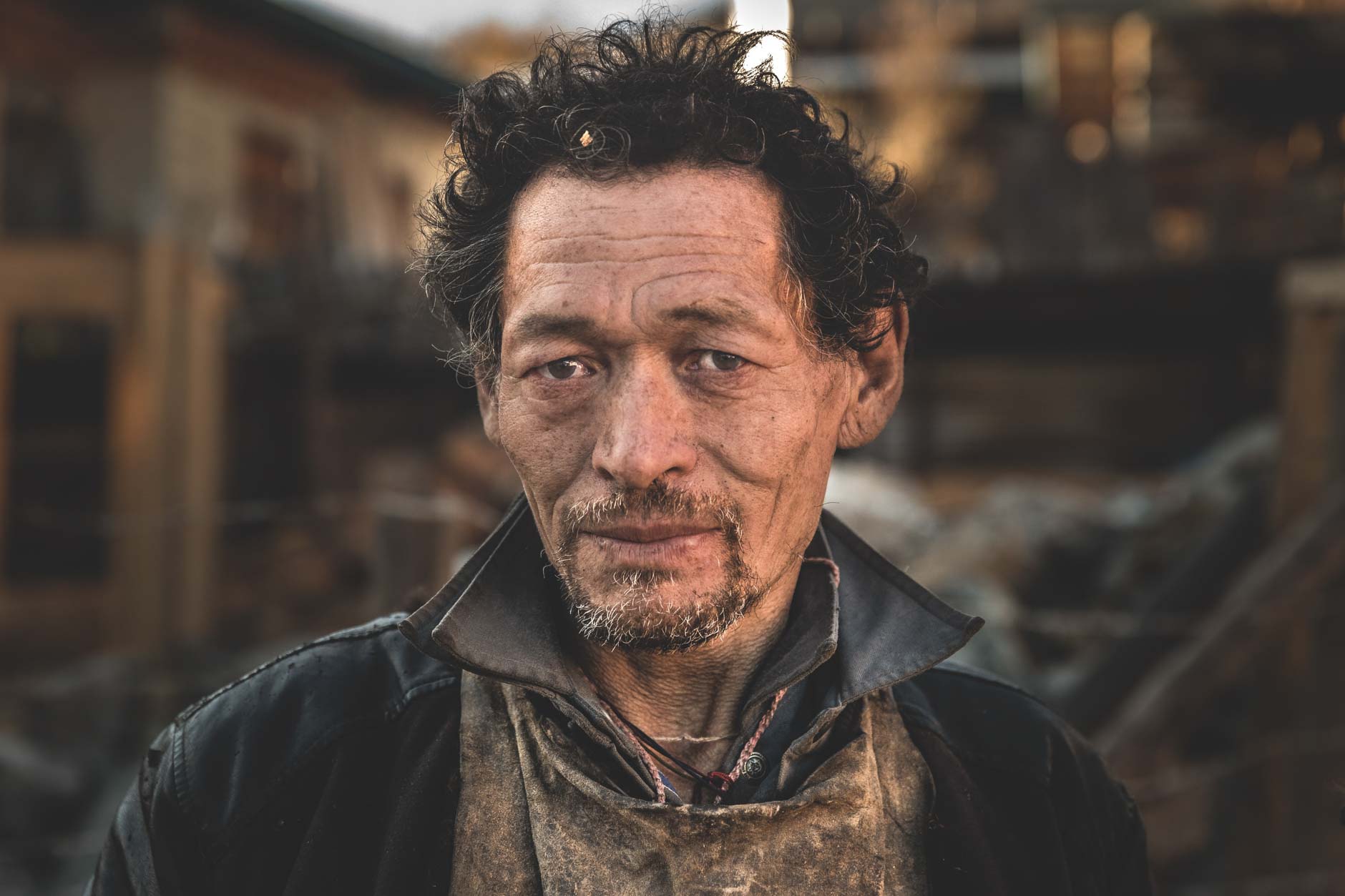 portrait photography of an elderly brokpa tribesman wearing a leather yak vest in Merak, Bhutan
