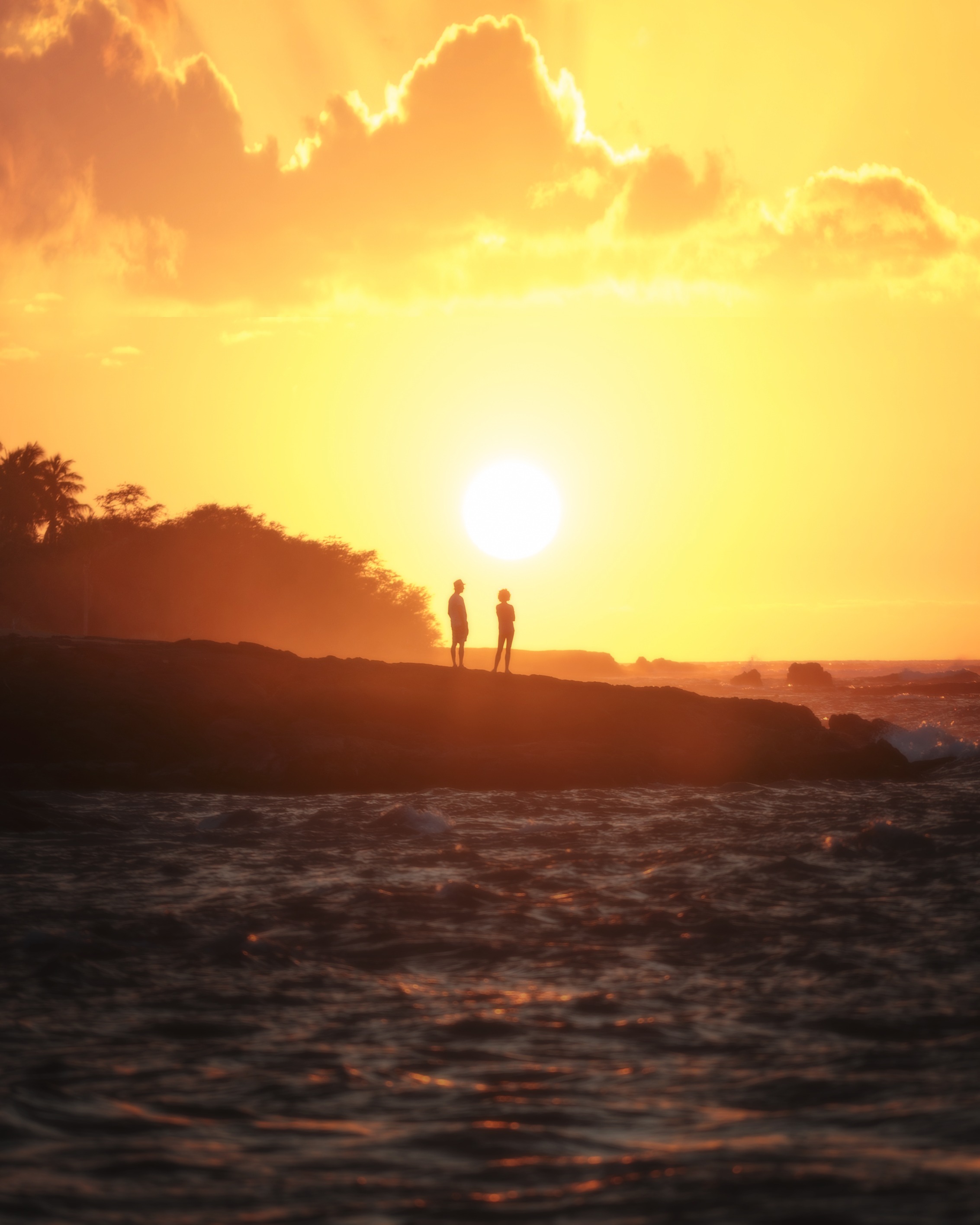 Photography of two people standing on the coast watching the sunset