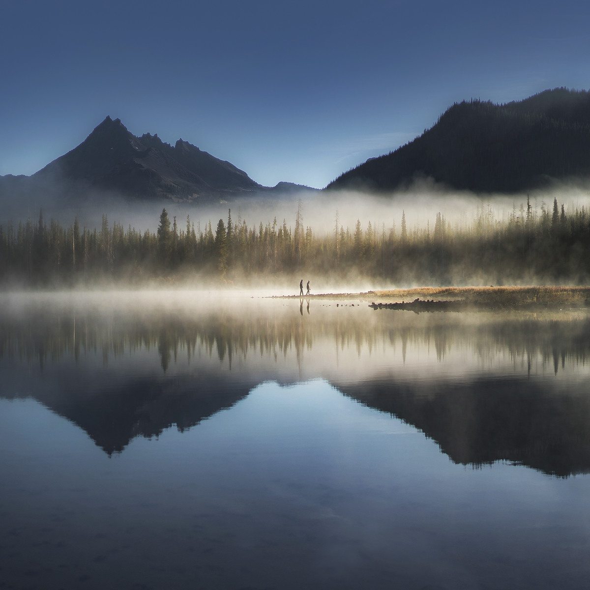 Landscape photography of two people walking at Sparks Lake, Oregon during sunrise Photo by Andrew Studer