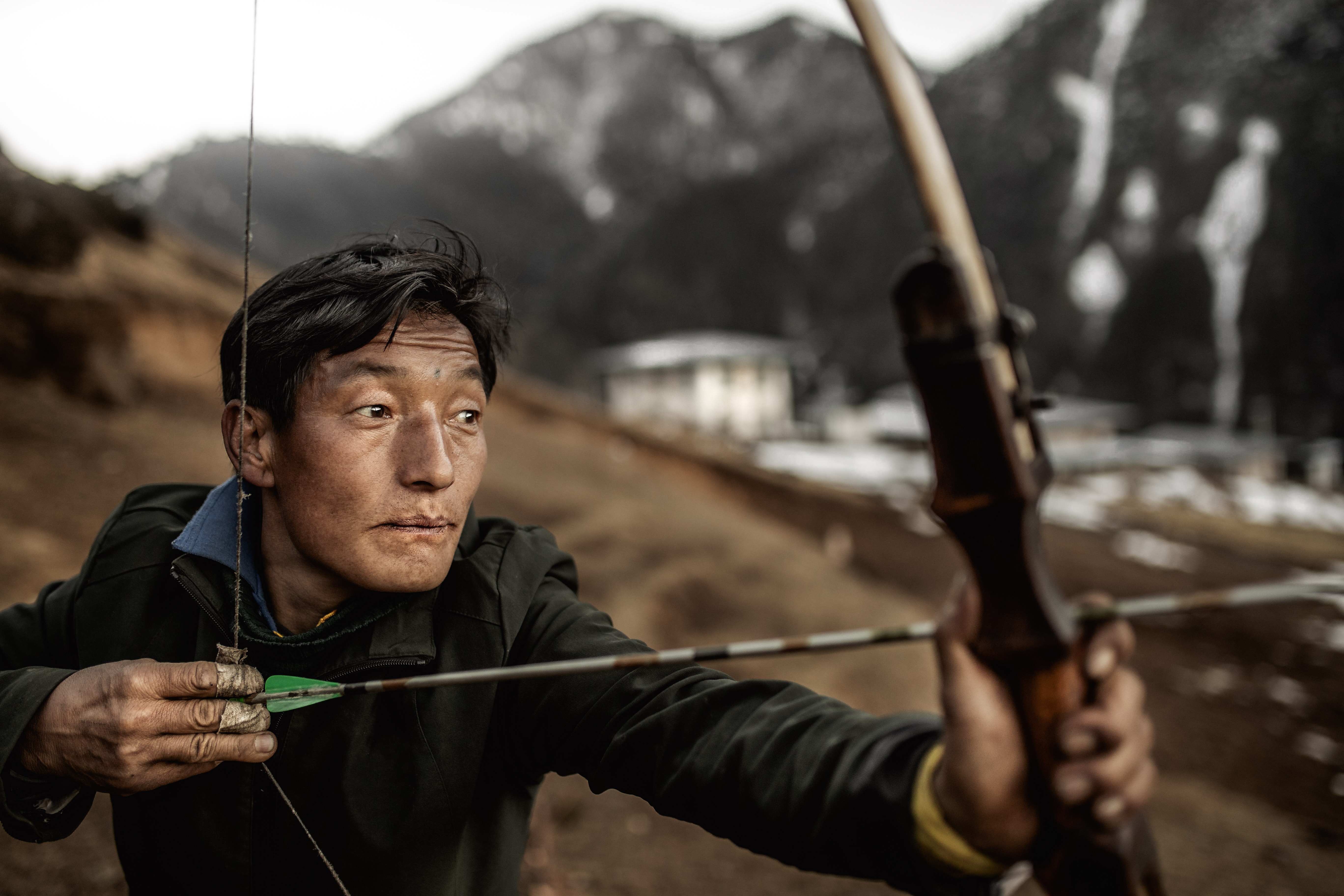 Photography of a brokpa tribesman doing archery in Merak, Bhutan