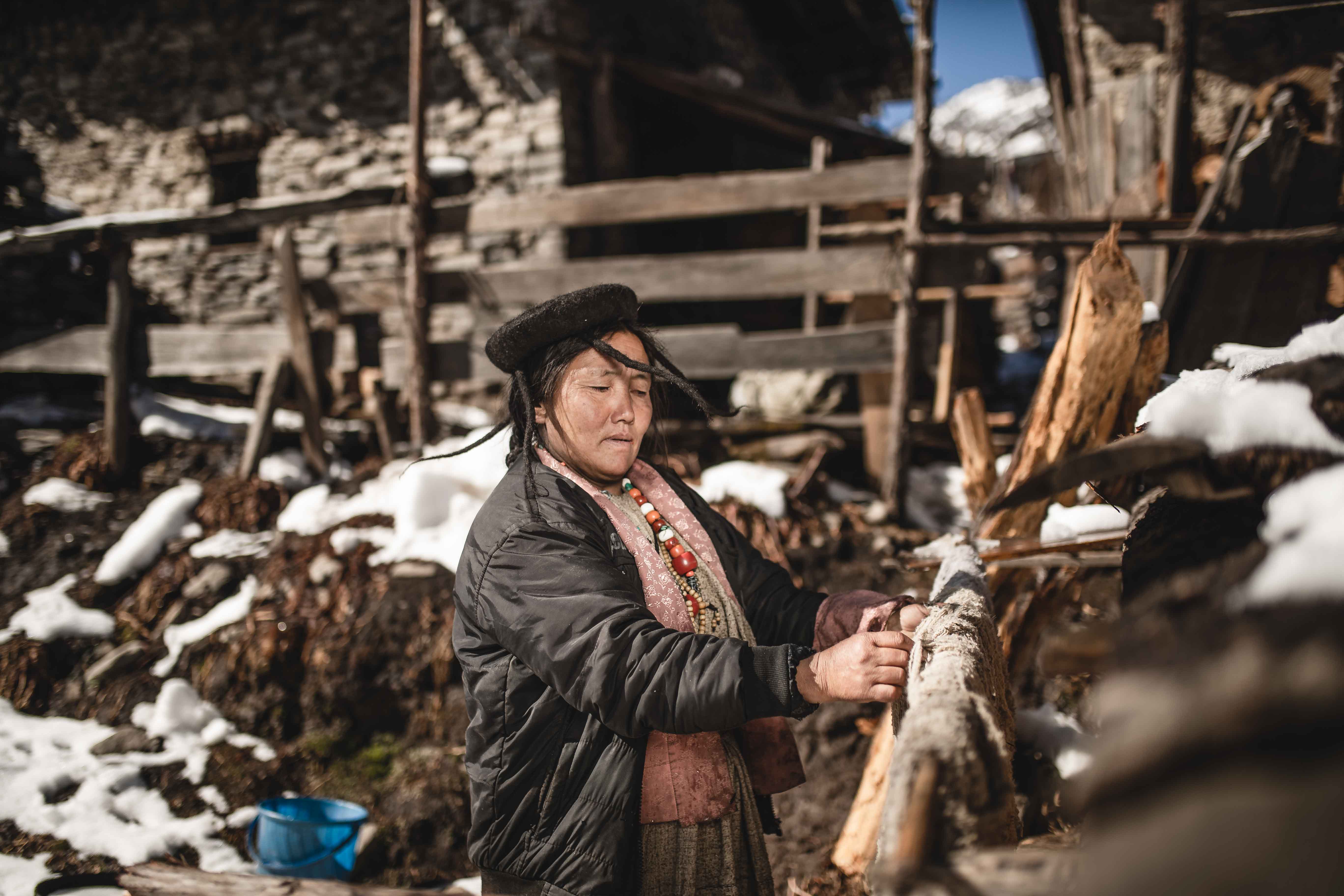 Street photography of a Brokpa tribeswoman working in the village