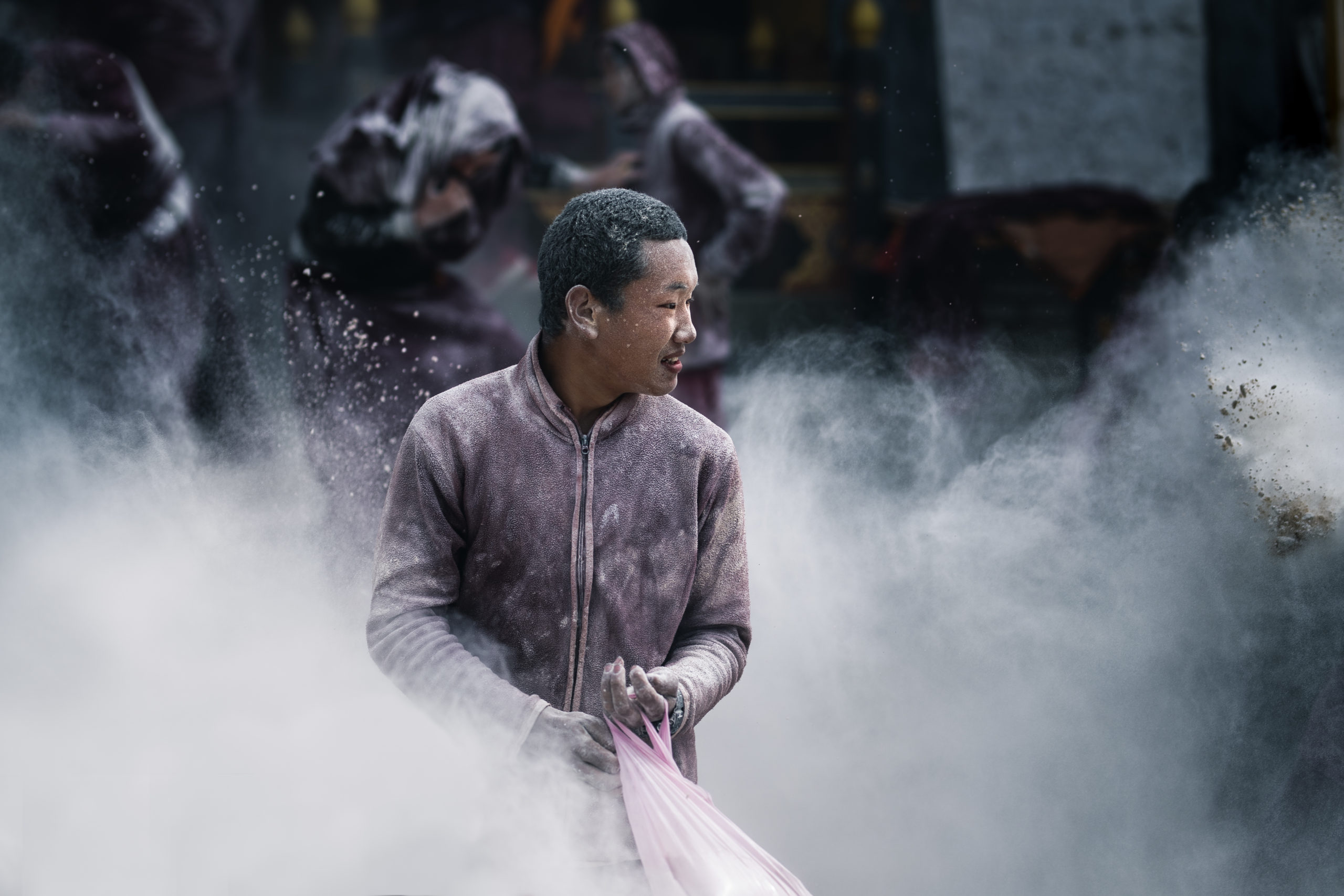 A Bhutanese monk celebrating the Losar Festival in Bhutan by throwing flour