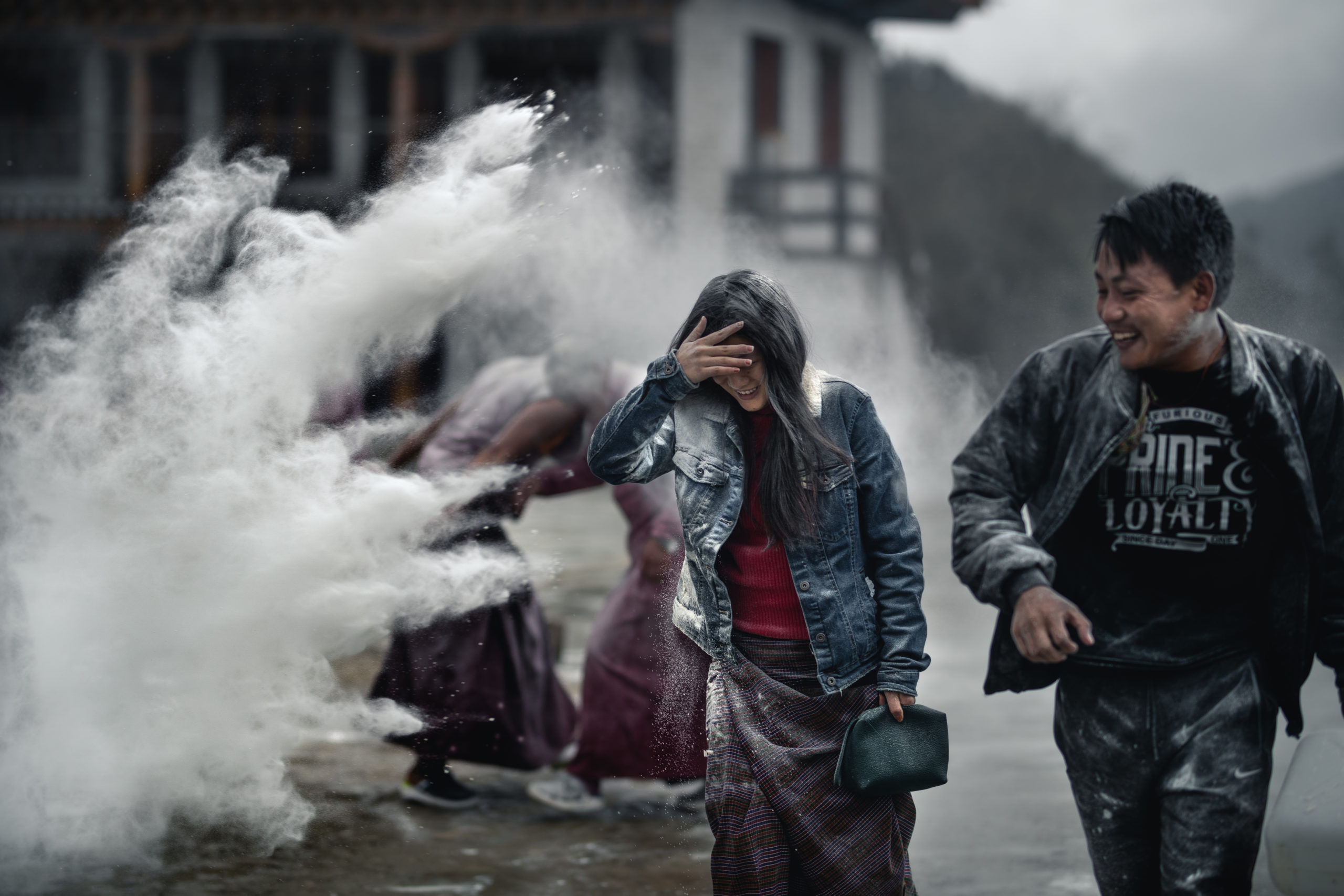 A Bhutanese woman finds herself amongst a flour battle during the Losar Celebration at a monastery in Bhutan