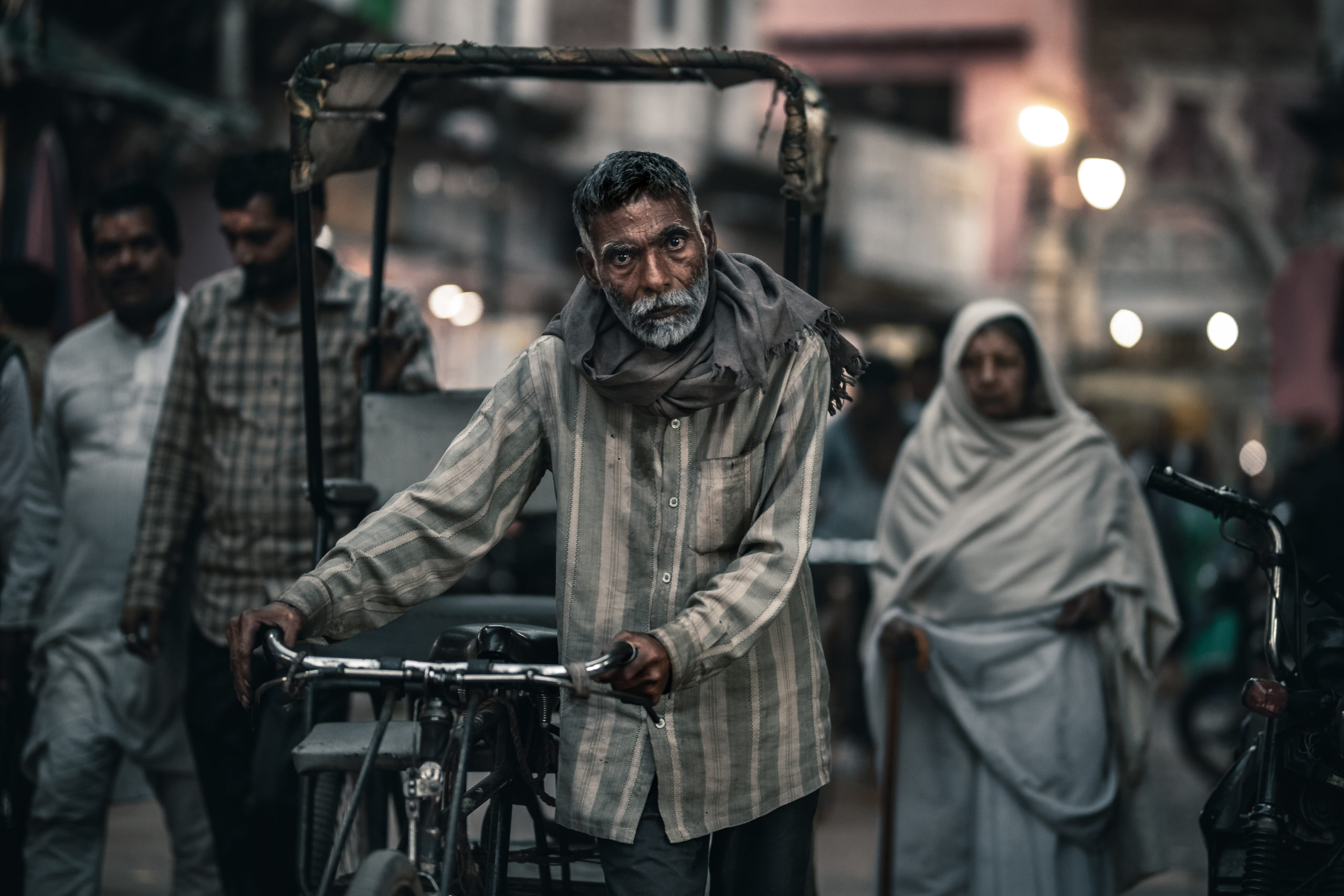 Portrait street photography of a rickshaw driver walking in the streets of Mathura, India