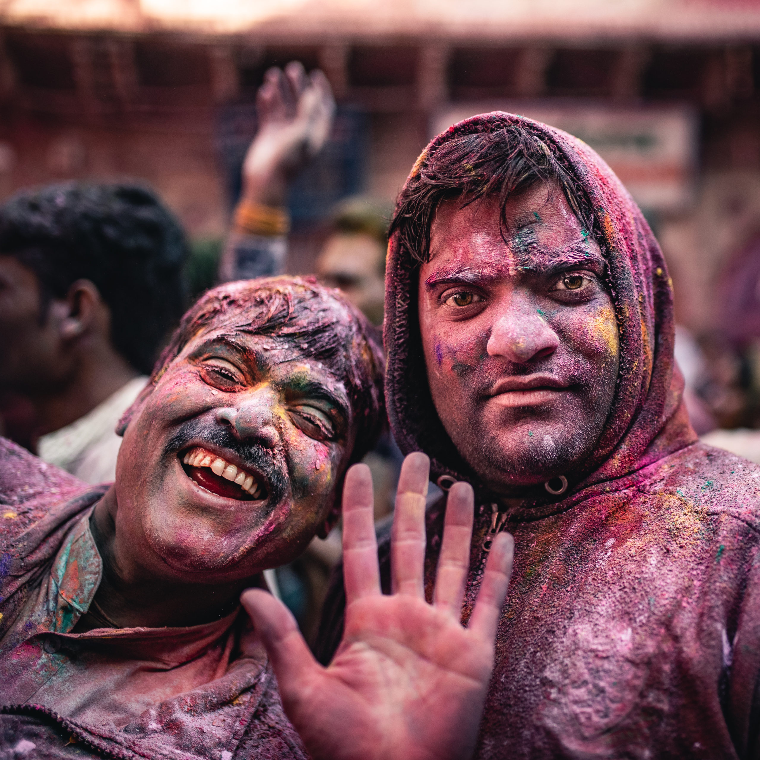 Street photography of men celebrating the Holi Festival in Vrindivan, India while covered in colorful powder