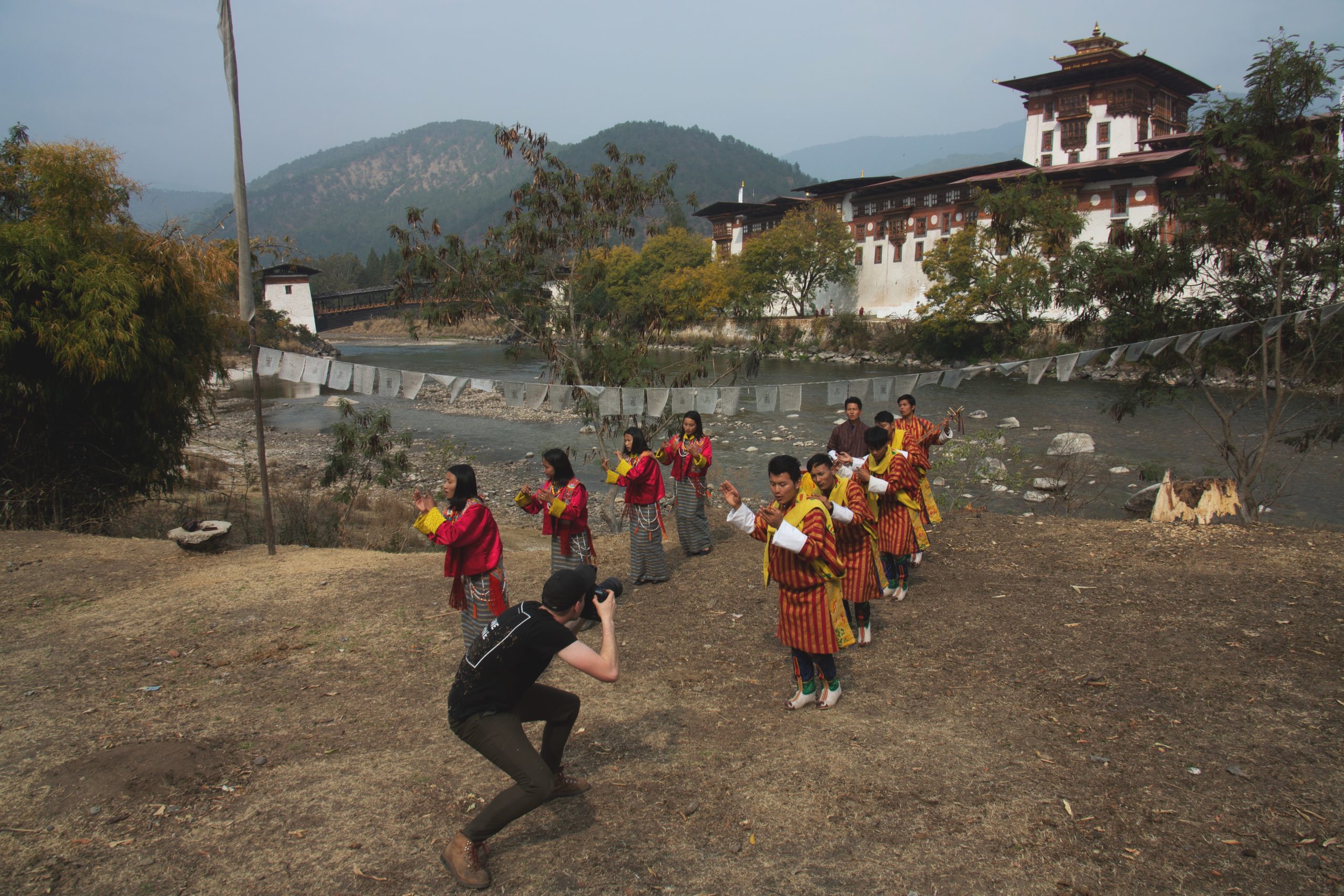 photographer andrew studer photographs traditional Bhutanese dancers in front of Punakha Dzong in Bhutan