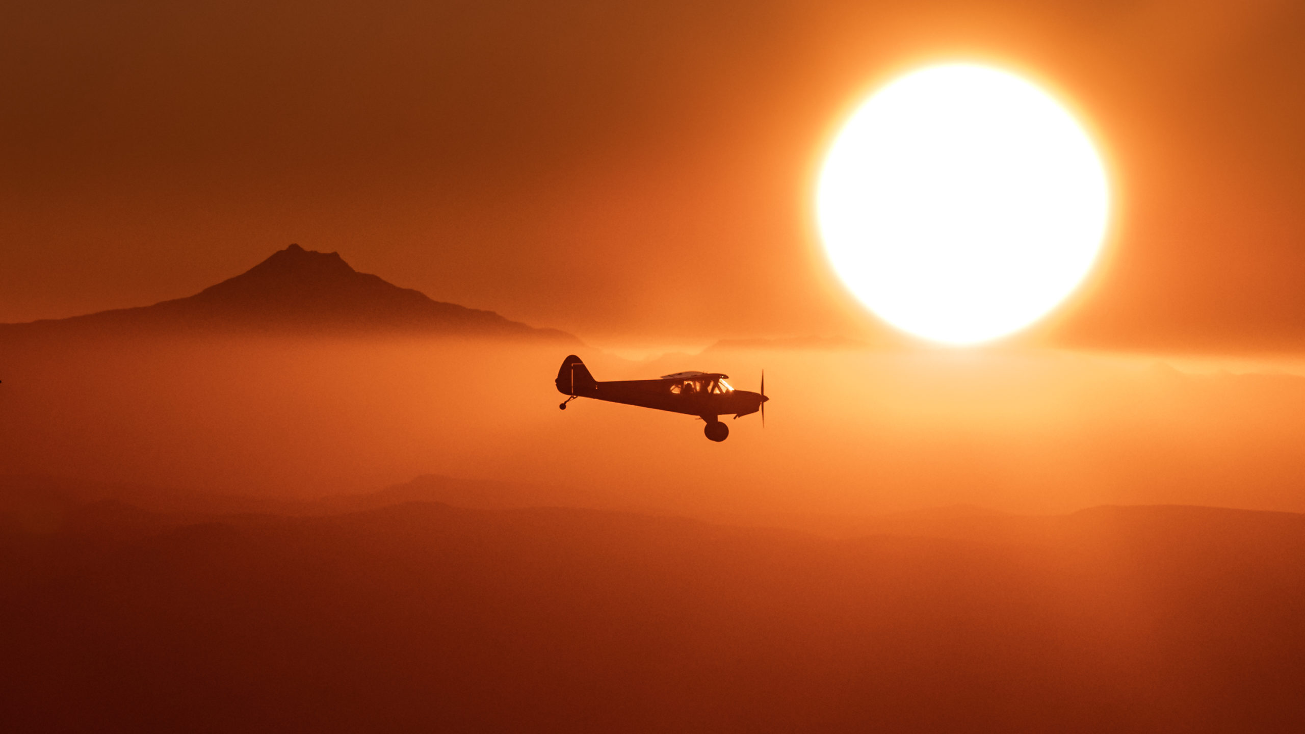 Aviation Landscape photography of a Carbon Cub airplane flying over Oregon during sunset.
