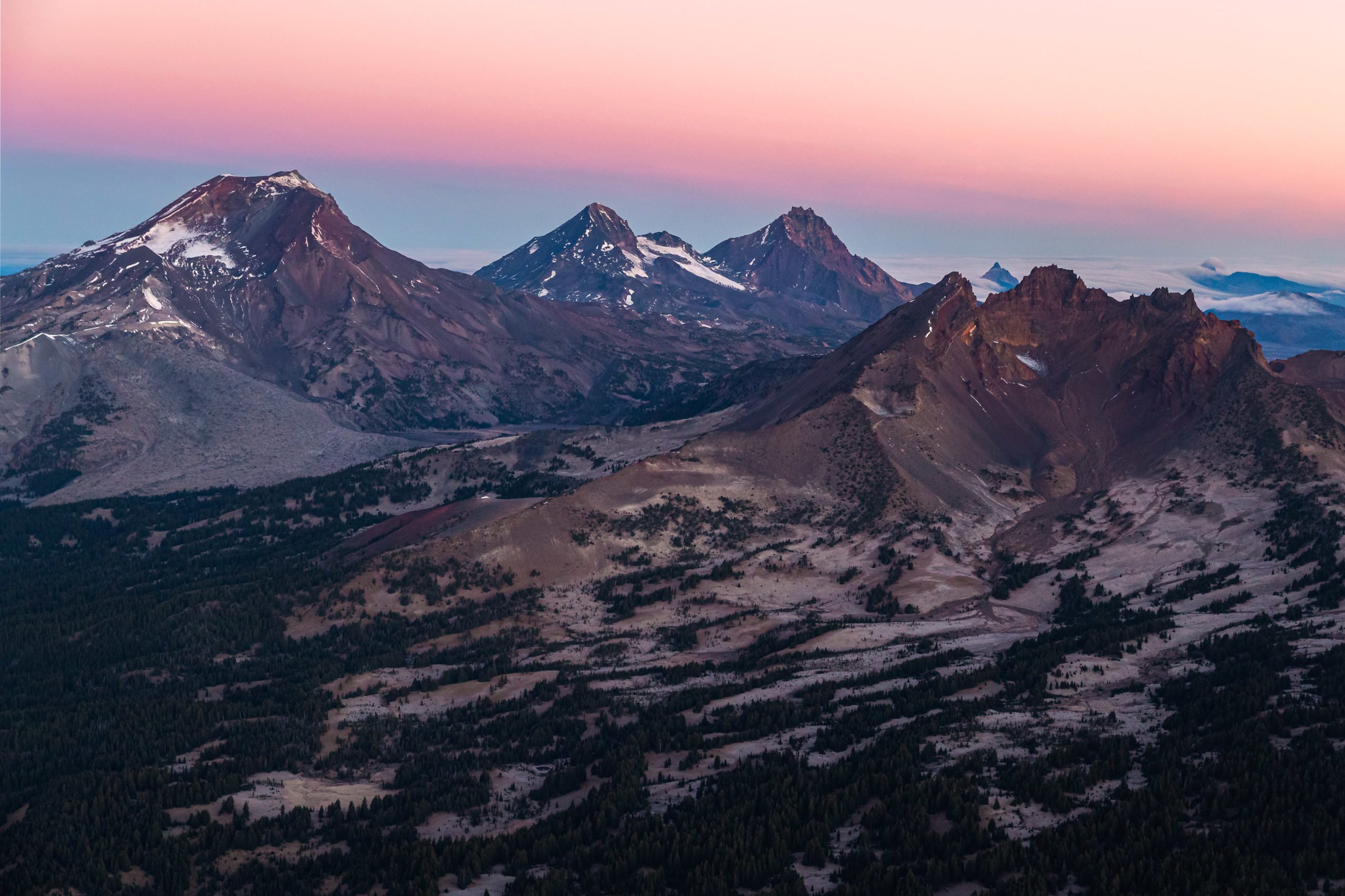 Aerial landscape photography of the Sisters Mountain Range in Oregon taken just before sunrise.