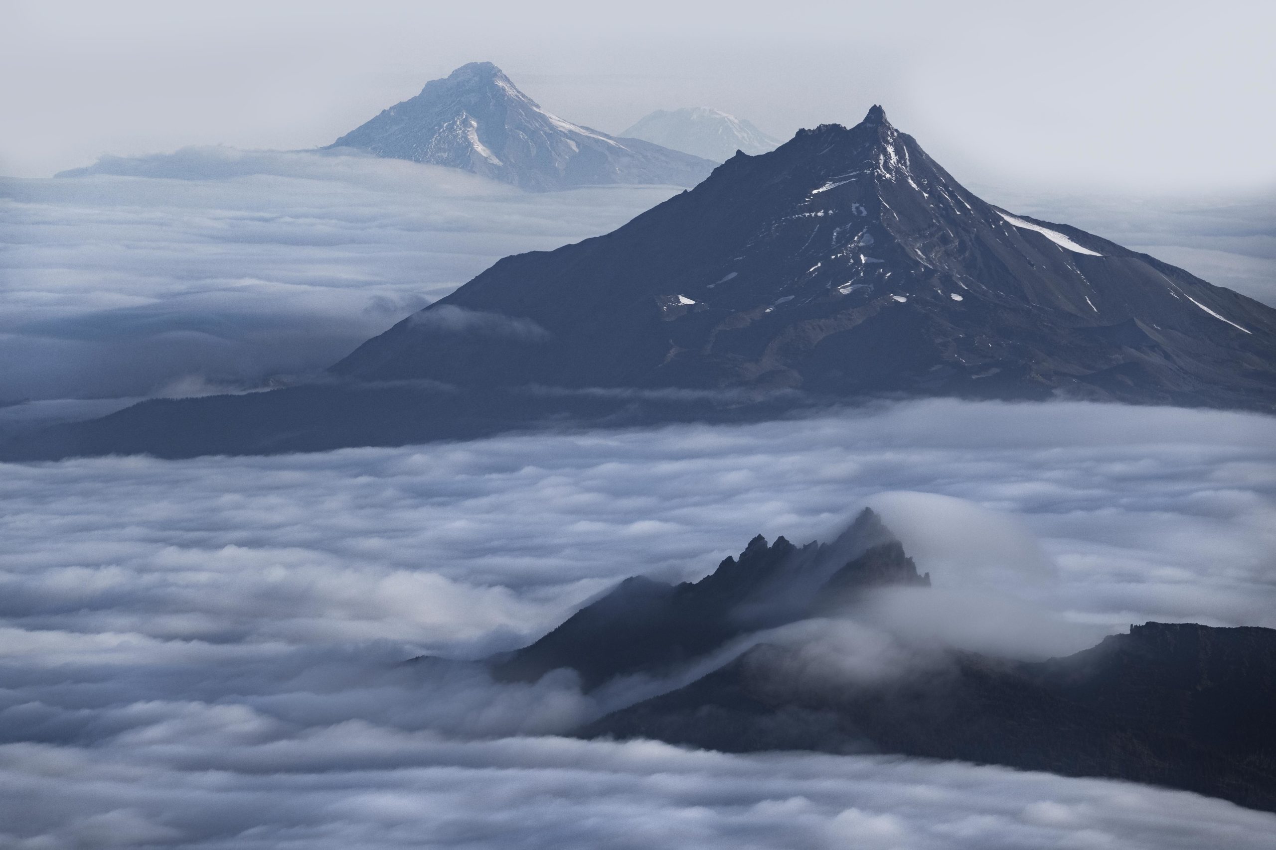 Aerial photography of Belknap Crater and Mount Washington above the clouds