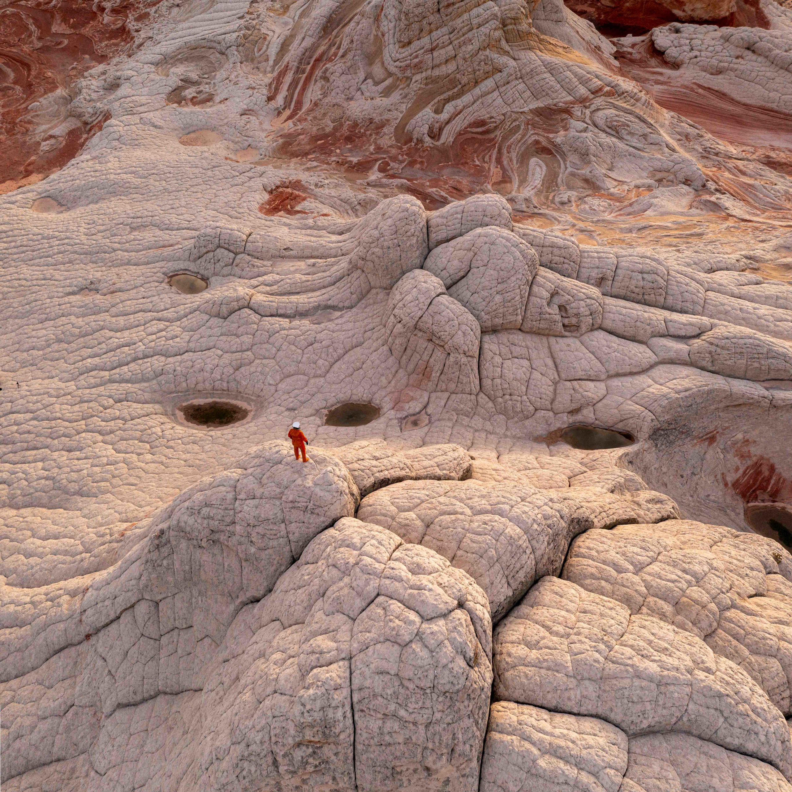 Photography of an astronaut exploring the otherworldly landscape of the American Southwest