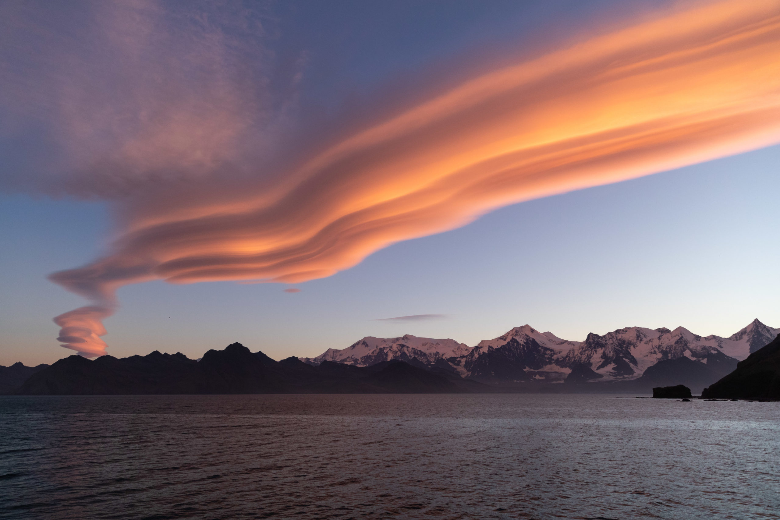 Landscape photography of lenticular clouds during a beautiful and colorful sunset on South Georgia Island