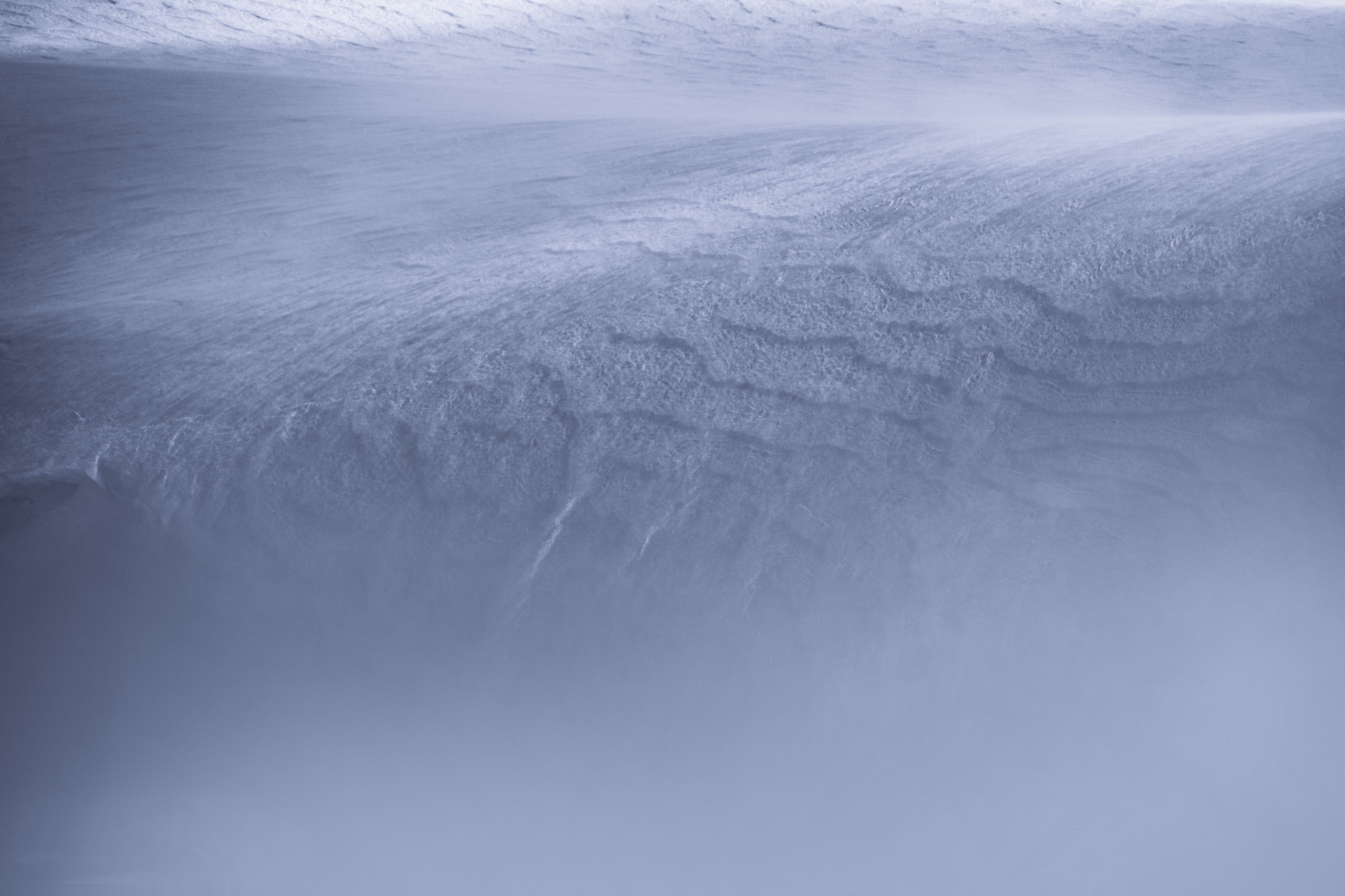 Abstract landscape photography of windswept snow patterns on a mountain in Antarctica
