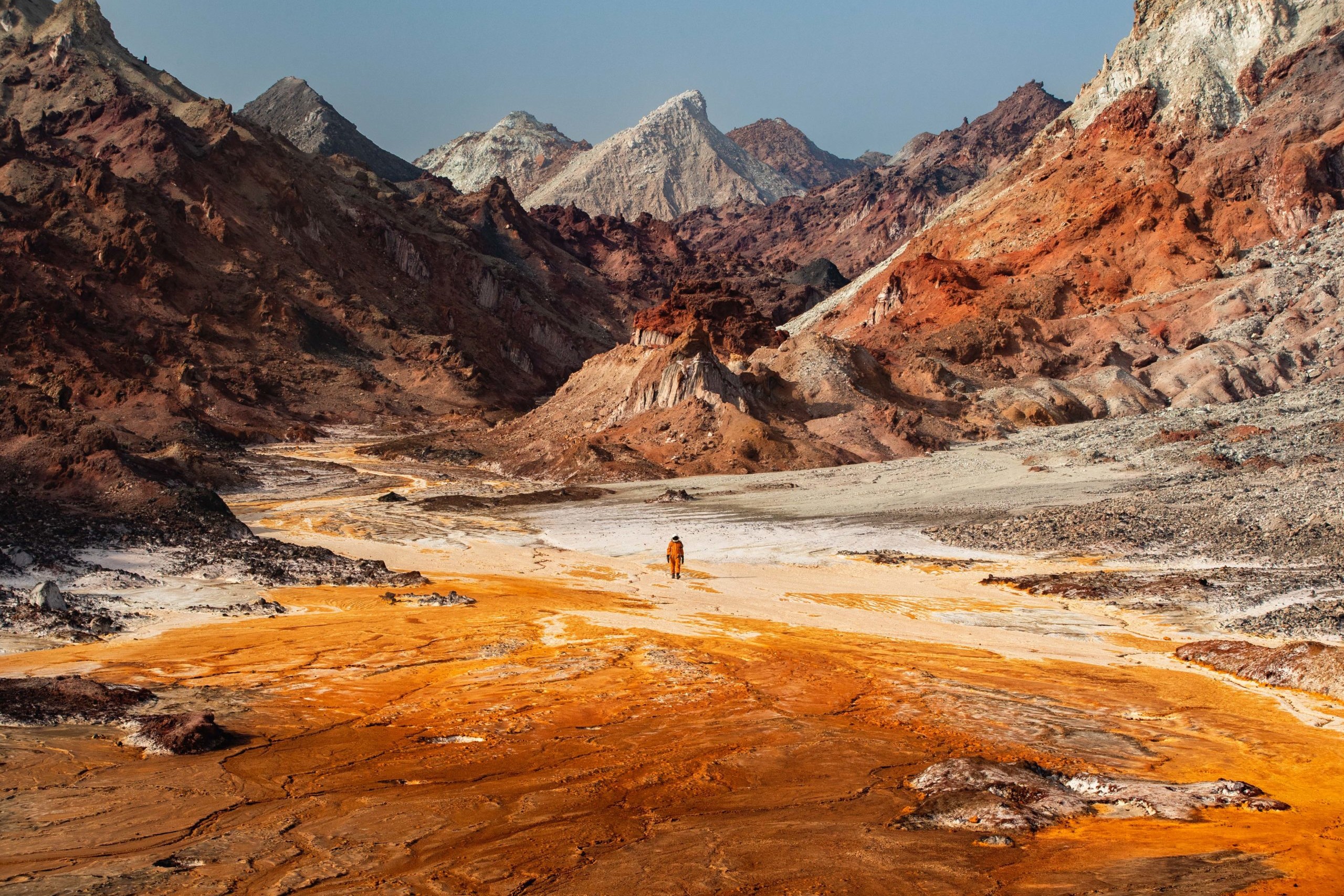 Landscape photography of an astronaut exploring the otherworldly landscape of a salt river in southern Iran