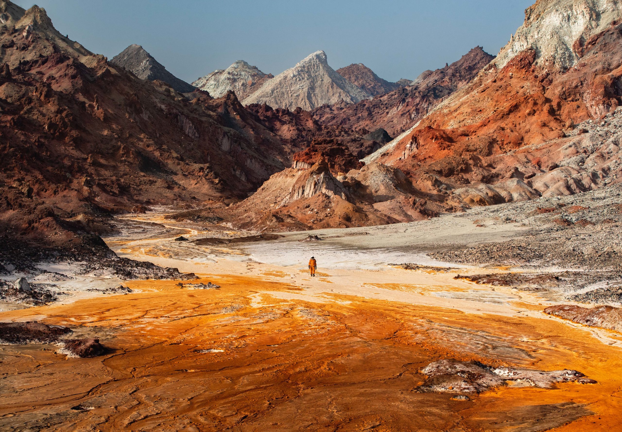 Landscape photography of an astronaut exploring the otherworldly landscape of a salt river in southern Iran