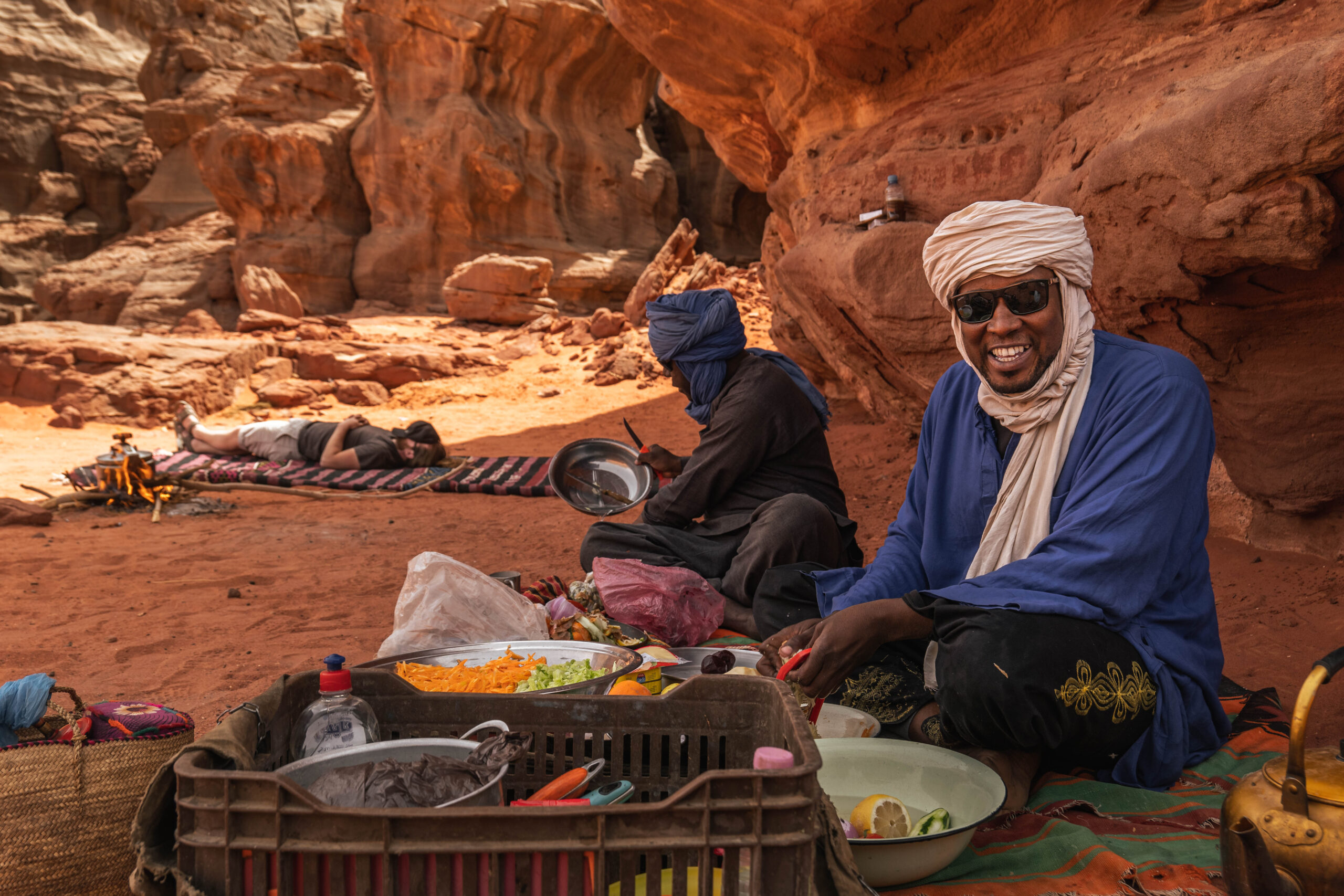 Tuareg guide Muhammad prepares lunch while 'astronaut' Niels Van De Linde takes an afternoon nap after a busy day of shooting in Algeria