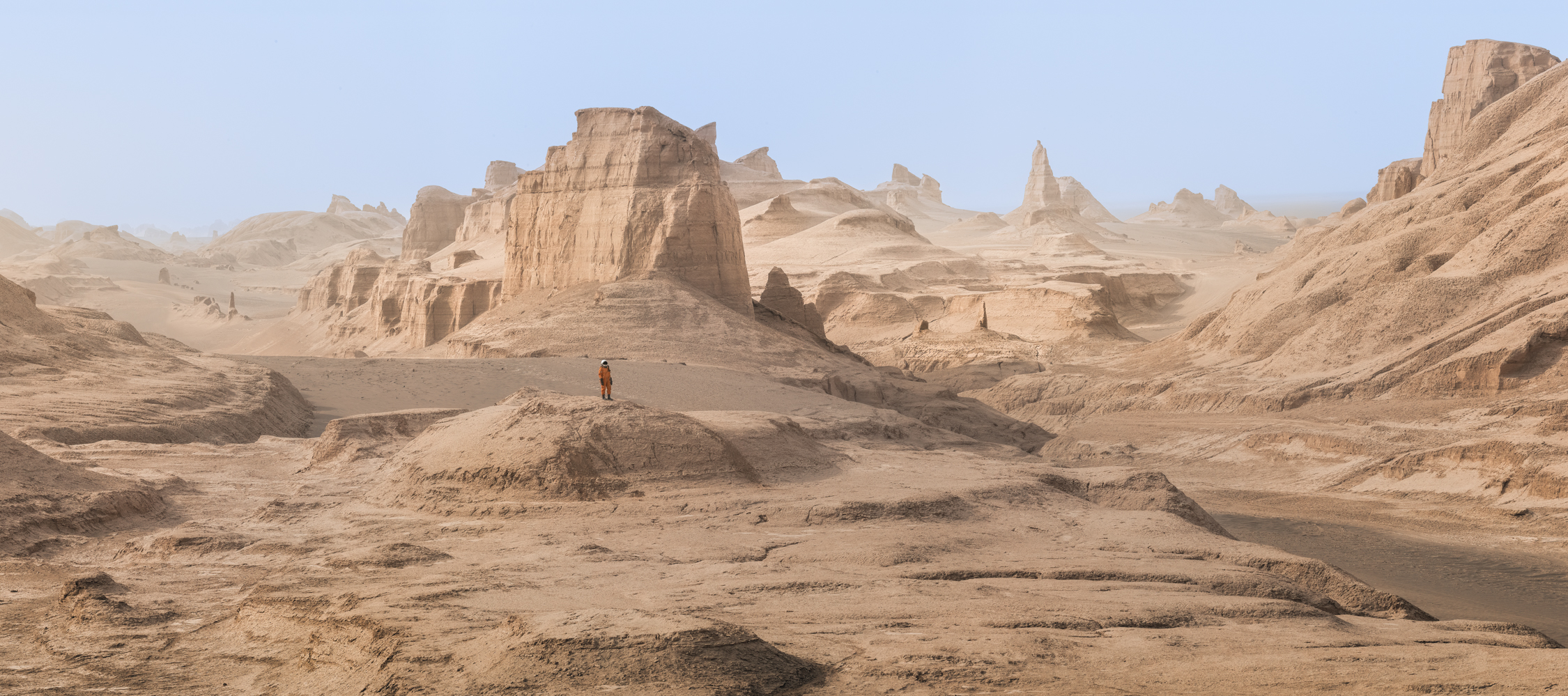 Astronaut in the alien-like landscsape of Iran's Lut Desert